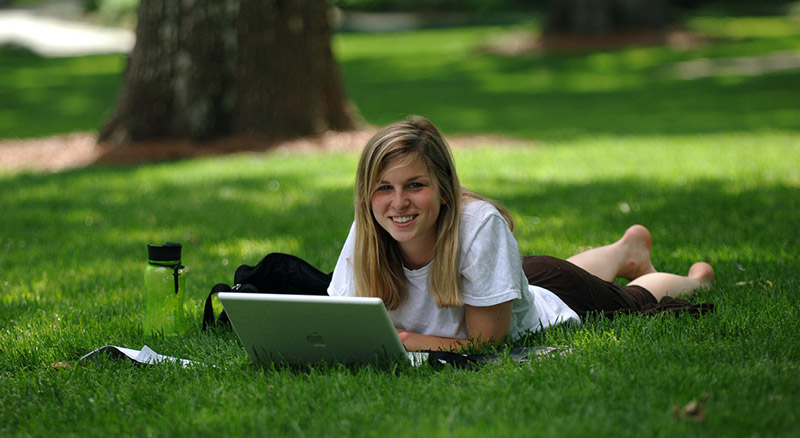 Female student with laptop in the Grove
