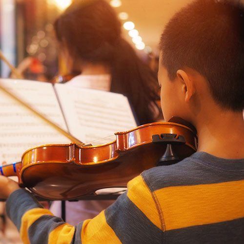 Child playing the violin in music class