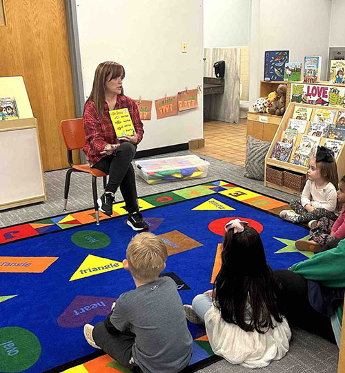 Rhonda Brown reads to school children in a classroom