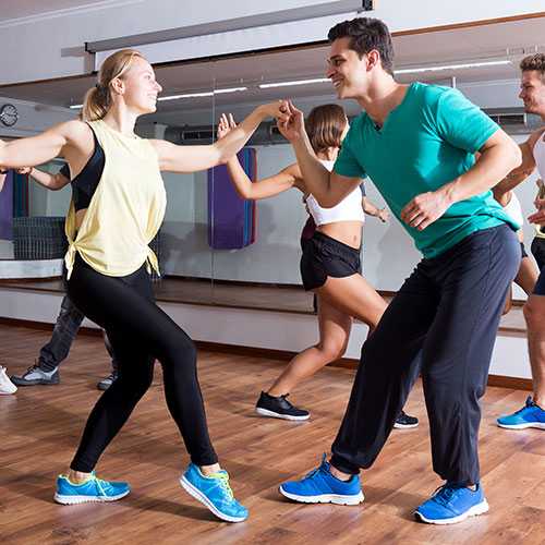 several couples in dance class learning ballroom moves