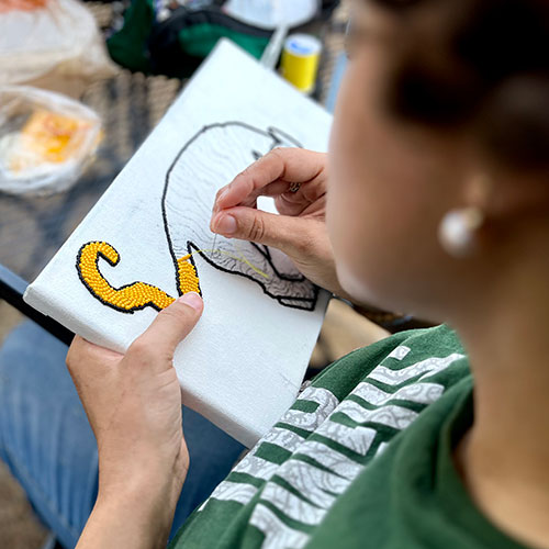 Student learning to bead using image of tiger
