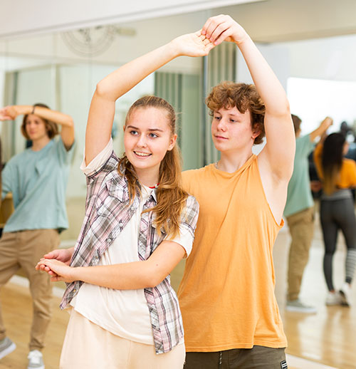 Two dance students learning salsa move in dance class