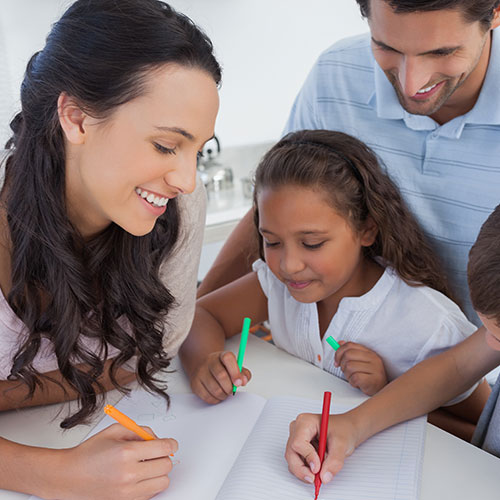Family at table with pens and paper