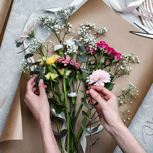 arrangement of flowers being prepared on brown craft paper