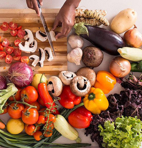 hands cutting healthy vegetables on a cutting board