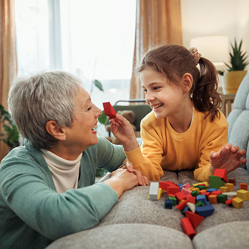 Grandmother playing blocks with young child