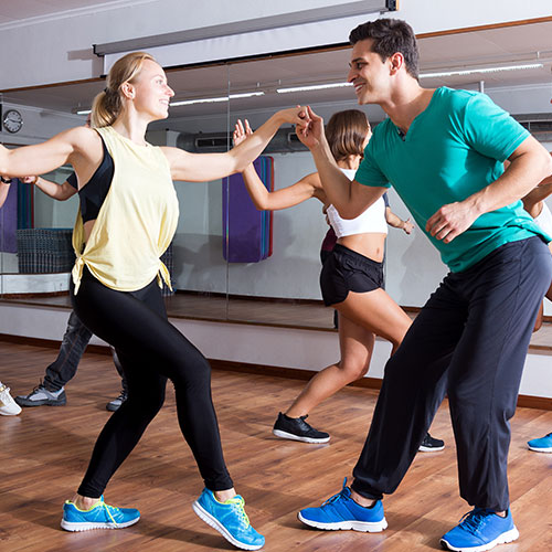 Two dance students learning salsa move in dance class