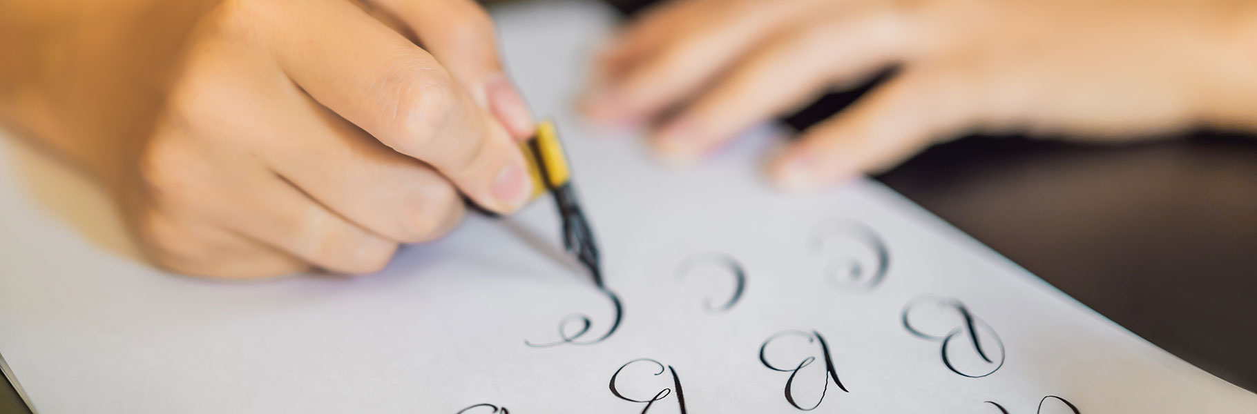 close up of hands doing calligraphy