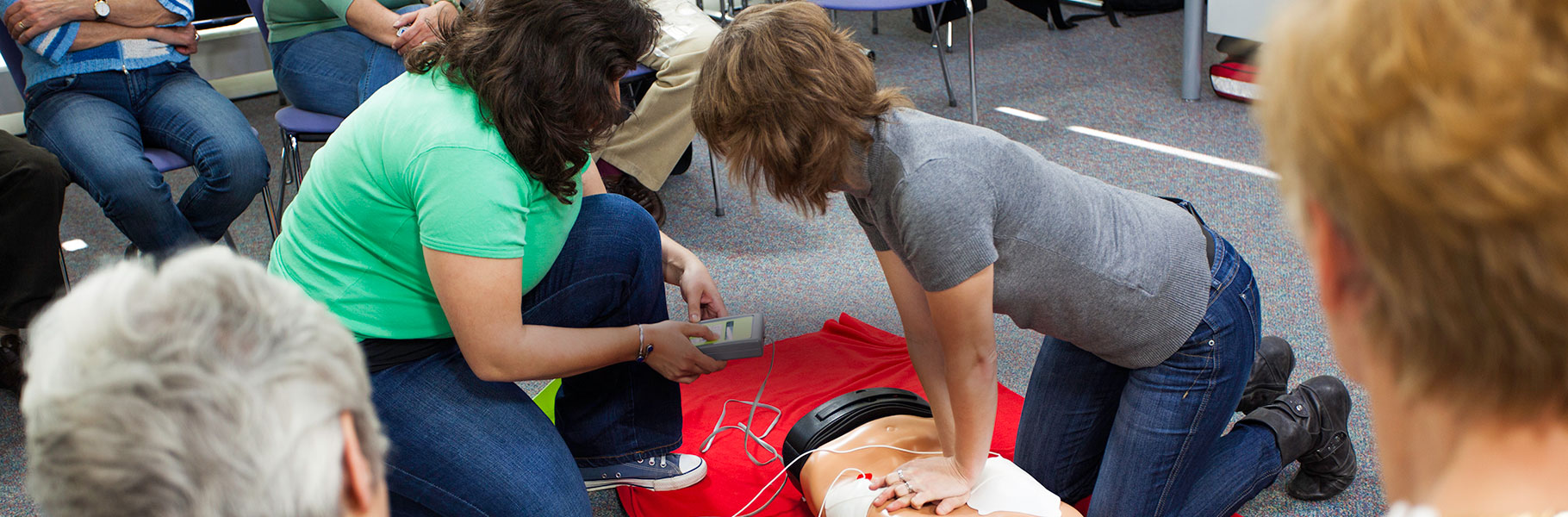 CPR class using dummy to administer aid
