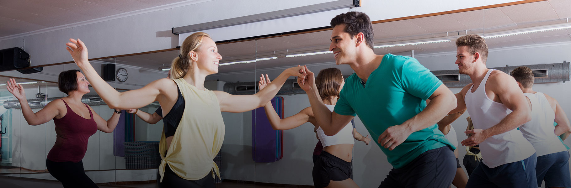Young smiling men and women dancing swing in dance studio