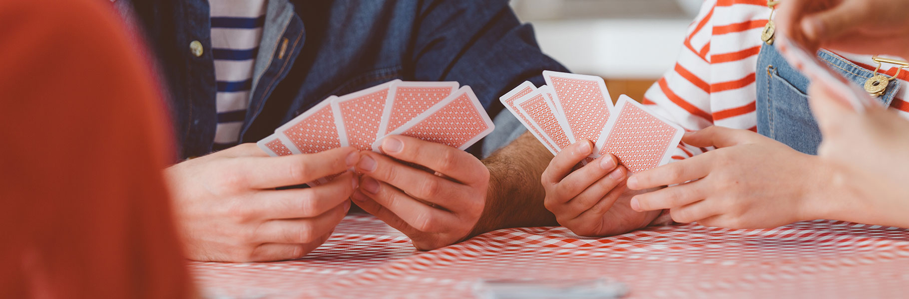 Two people's hands shown playing cards