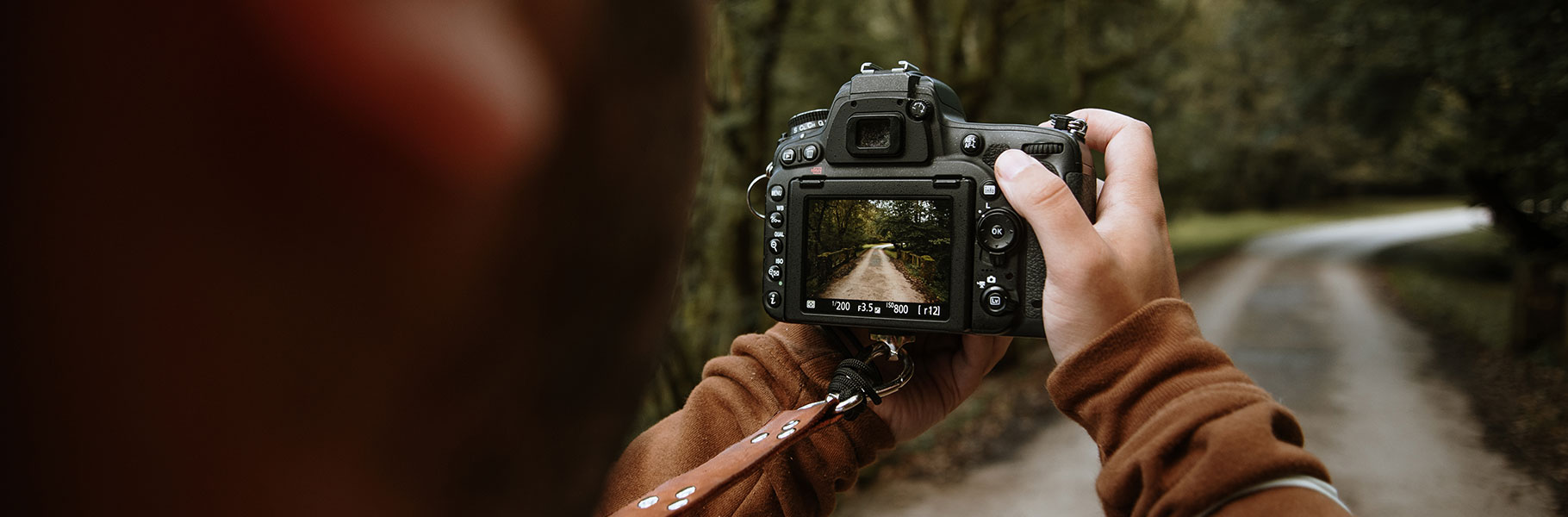 Person taking photo of road, seen through digital viewfinder