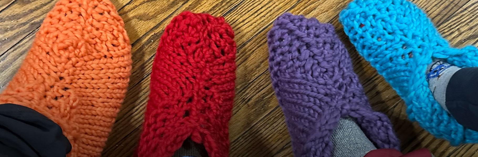 feet wearing colorful knit slippers