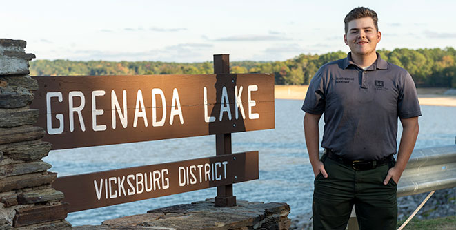 Student in front of Grenada Lake sign