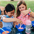 Two students in rebel quest camp mixing paints