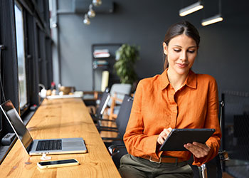 HR professional looking at tablet while at desk