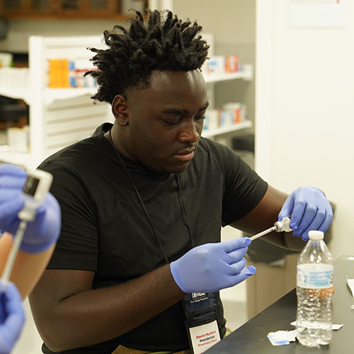 High school aged student working in lab doing an experiment