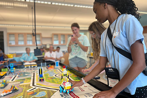 student working on robotics racing project with other students