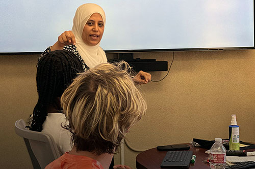 Arabic language instructor talking to a class with student in foreground