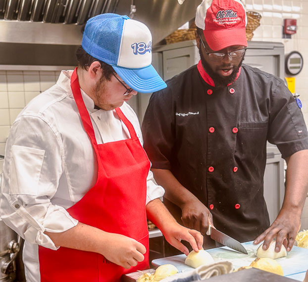 student and instructor working in kitchen