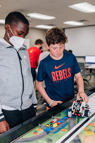 Two robotics students working on a project