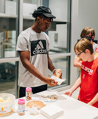 Jalen Wells giving students an icecream social at Rebel Quest program