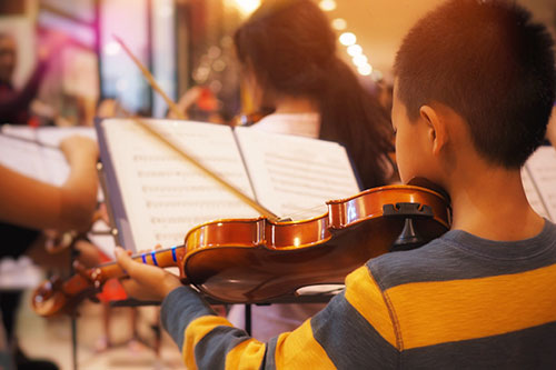 Child playing violin in music class