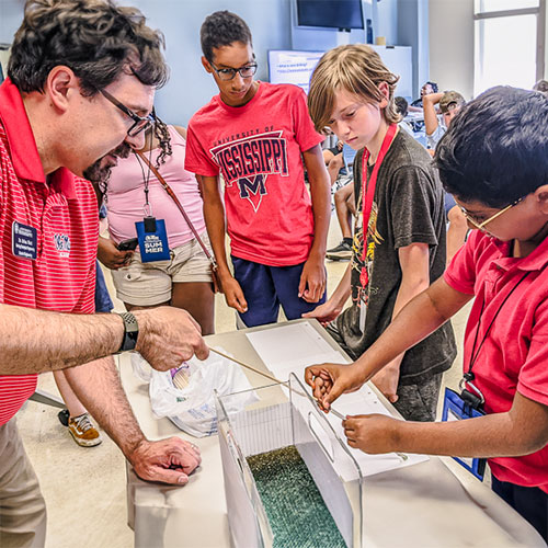 student and faculty examining sample from water