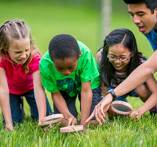 two children and a counselor working with clay