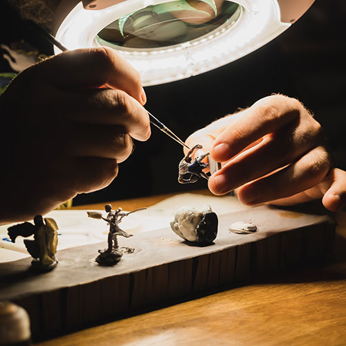 hands under worklight creating figurines