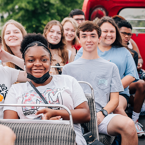 students taking double decker bus tour during program