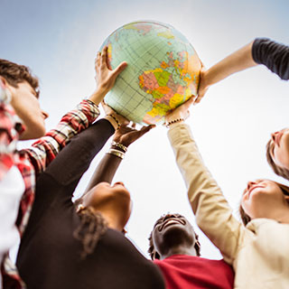 students holding up globe