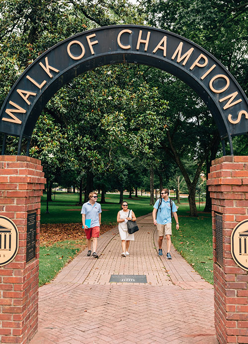 Students and Staff walking down the Walk of Champions in the Grove
