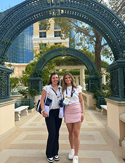 two students posing under outdoor arch at conference