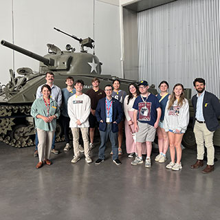 students posing in front of WW2 tank