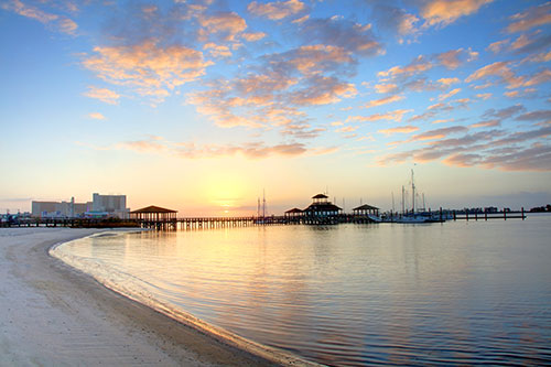 View of gulf with long pier and bots in distance