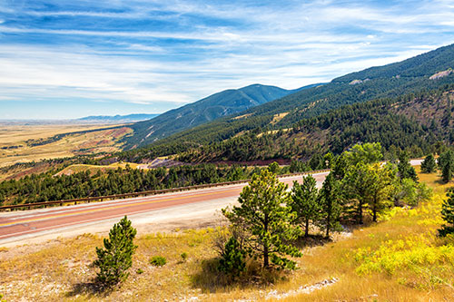 view of landscape around Sheridan, Wyoming with road winding through scrubby mountains
