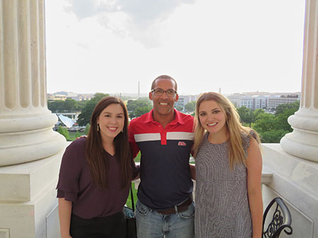 Students and professor under columns of the Capital building in Washington DC