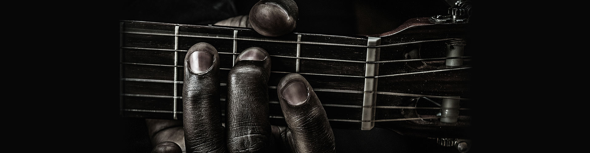 Fingers strumming blues guitar close up