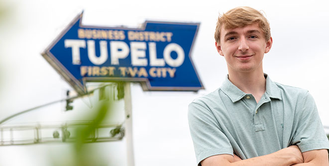 Student in front of the iconic Tupelo TVA sign