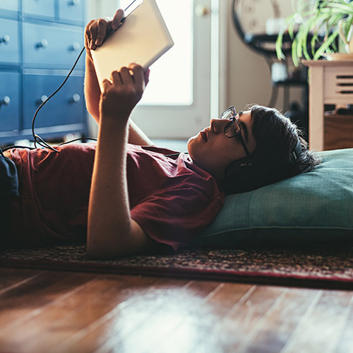 student relaxing with tablet, reading